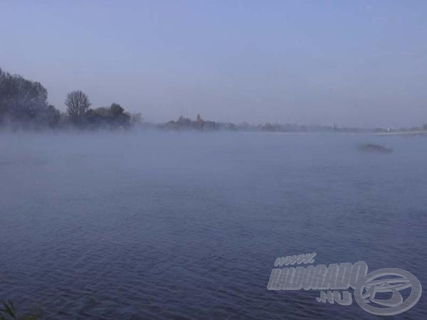 Hajnali ködbe burkolózott melegvizes tó