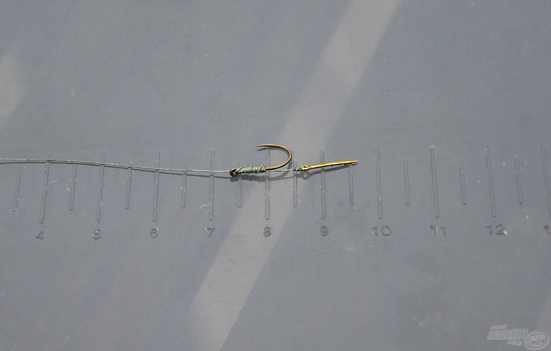 3. lépés: Le kell vágni a megfelelő hosszúságú zsinórt, amely elegendő a kb. 8 cm-es horogelőke elkészítéséhez