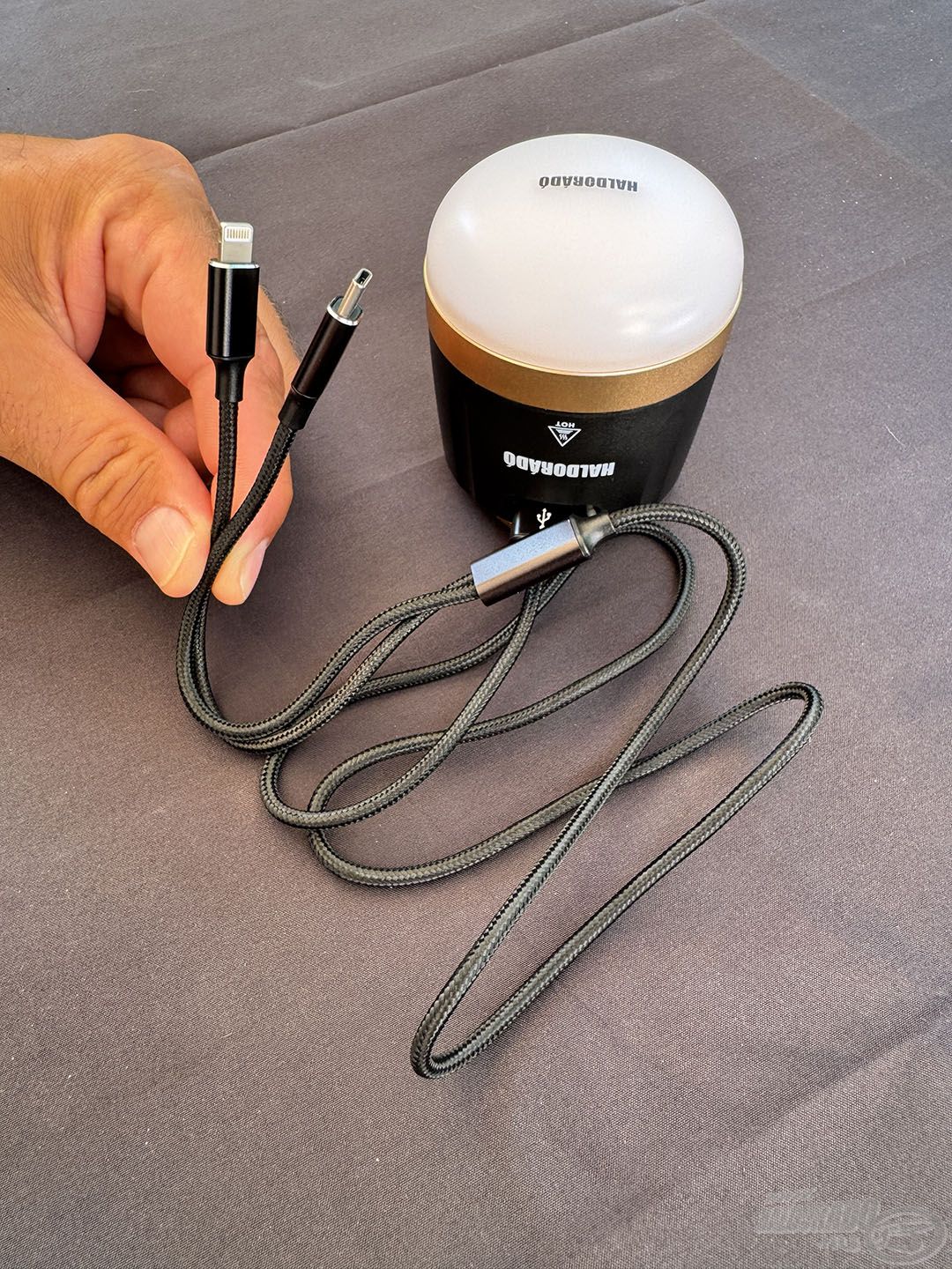 A csomagban található egy USB-C és iPhone Lightning csatlakozóval ellátott töltőzsinór